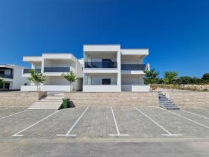 a large white building with a parking lot at Villa AISHA with private jacuzzi in Novalja