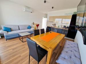 a kitchen and living room with a table and a couch at Villa AISHA with private jacuzzi in Novalja