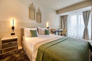 um quarto de hotel com uma cama grande e uma mesa em Alezzi Infinity Aparthotel & Spa em Mamaia Nord – Năvodari