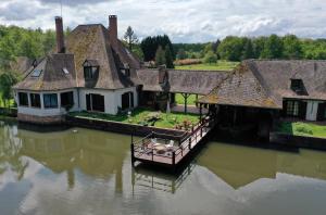 una casa sull'acqua con una barca dentro di Manoir de la Sauldre ad Argent-sur-Sauldre