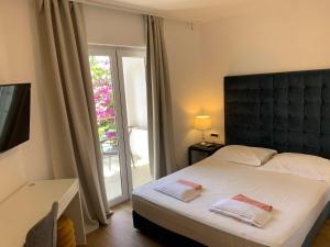 Un dormitorio con una cama grande y una ventana en Gargamelo Pension en Poreč