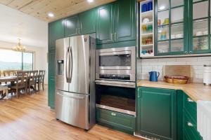 a kitchen with green cabinets and a stainless steel refrigerator at Walling Mountain Retreat in Groveland
