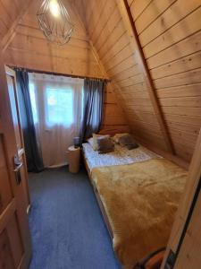 a room with two beds in a attic with a window at Domek Góralki in Zakopane