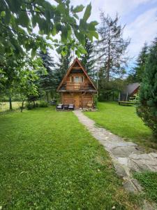 a log cabin in the middle of a green field at Domek Góralki in Zakopane