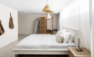 a white bedroom with a large white bed with white pillows at Hotel Anilevich Mansion in Beer Sheva