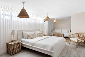 a white bedroom with a large bed and a couch at Hotel Anilevich Mansion in Beer Sheva