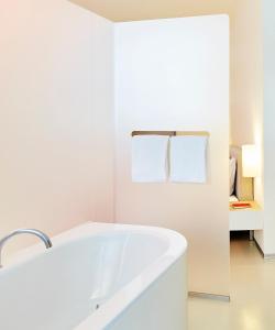 ein weißes Badezimmer mit einer Badewanne und einem Waschbecken in der Unterkunft Greulich Design & Boutique Hotel in Zürich