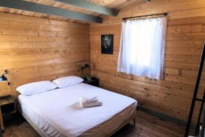 ein Schlafzimmer mit einem weißen Bett in einem Holzzimmer in der Unterkunft Finca Florida in Benalup Casas Viejas