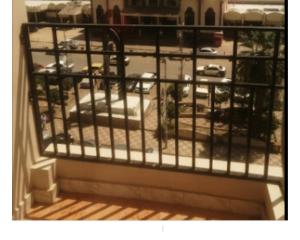 a balcony with a view of a parking lot at Salvatore Rooms With Breakfast -Train Station in Mansoura