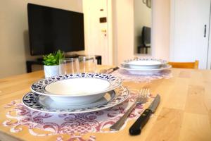 uma mesa com dois pratos e utensílios em * La Casa di Arti * 25 min dal Duomo em Milão