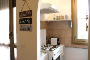 uma pequena cozinha com fogão e uma placa na parede em * La Casa di Arti * 25 min dal Duomo em Milão