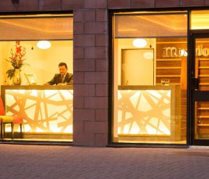 um homem sentado numa mesa numa vitrine em Mondo Hotel em Coatbridge