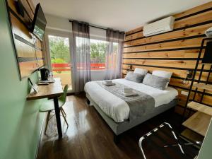 a bedroom with a bed with a wooden wall at Hôtel Paris Madrid in Lesperon