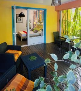 a living room with a couch and a bed at Hôtel les Bougainvilliers in Saint-Gilles-les-Bains