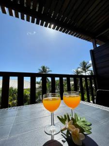 dos vasos de zumo de naranja sentados en una mesa en Hôtel les Bougainvilliers en Saint-Gilles-les-Bains