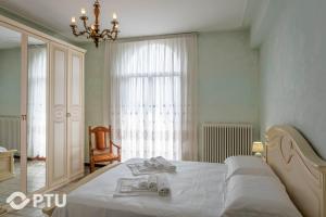1 dormitorio con 1 cama blanca grande y toallas. en PoloTuristicoUmbria Villa del Maestrale, en Perugia