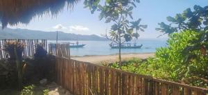 a view of a beach with boats in the water at the village rua beach homestay in Rua