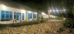 a building with blue windows and a table in front of it at the village rua beach homestay in Rua +22 photos