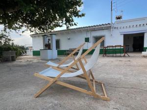 einem Holzstuhl vor einem Gebäude in der Unterkunft MASIA ESTORACH in L'Aldea