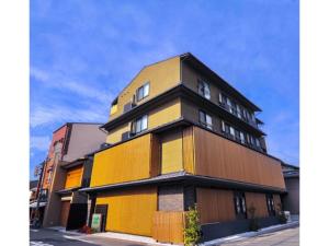 um edifício amarelo e castanho numa rua em HIZ HOTEL Kyoto Nijo Castle - Vacation STAY 12563v em Quioto