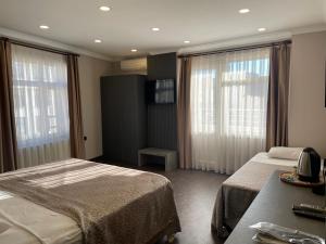 ein Hotelzimmer mit 2 Betten und 2 Fenstern in der Unterkunft Keles Hotel in Rize