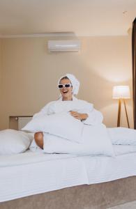 a woman sitting on a bed in a hotel room at Eduard Hotel in Uzhhorod +142 photos