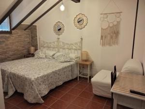 1 dormitorio con 1 cama, 1 mesa y 1 silla en Posada La Cerra de San Roque, en Santillana del Mar
