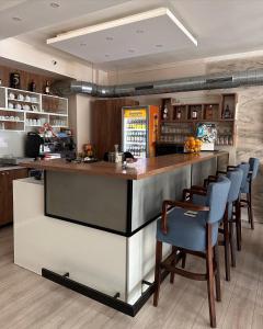 a kitchen with a bar with blue chairs at Motel Centar in Bijeljina
