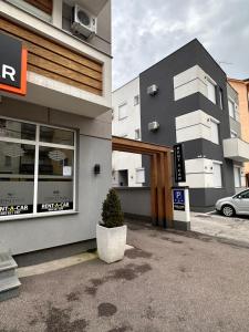 un edificio con un coche aparcado delante de él en Motel Centar, en Bijeljina