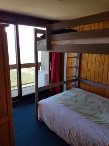 una camera da letto con un letto a castello e una finestra di Appart Le Corbier avec magnifique vue aérienne a Villarembert