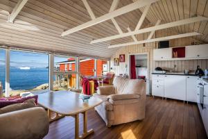 Jomsborg Ilulissat في إيلوليسات: مطبخ وغرفة معيشة مع طاولة وكراسي