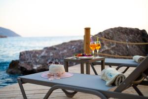 een picknicktafel met een hoed en glazen op het strand bij La Boheme Kabak in Faralya