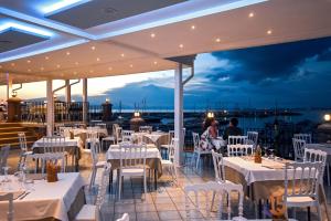 restauracja z białymi stołami i krzesłami oraz widokiem na ocean w obiekcie La Sciabica w Agropoli