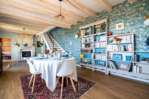 a dining room with a table and bookshelves at Le Clos Eugénie in Gennes