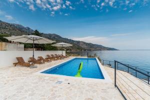 a swimming pool next to a body of water at Luxury Villa Solis in Karlobag