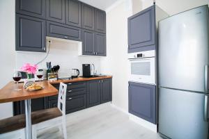 a kitchen with black cabinets and a refrigerator at AB Apart Comfort 5311 in Astana