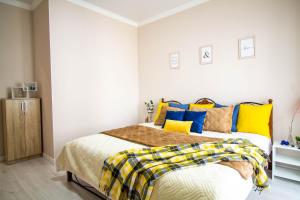 a bedroom with a bed with yellow and blue pillows at AB Apart Comfort 5311 in Astana