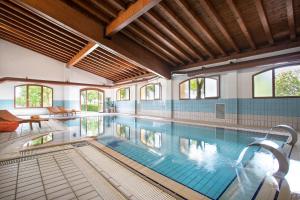 a large swimming pool in a building at Ancora Sport Hotel in Meolo