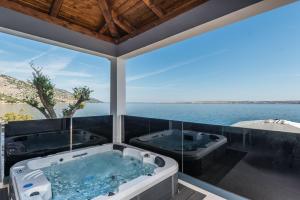 two jacuzzi tubs in a room with a view of the ocean at Luxury Villa Solis in Karlobag
