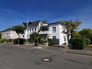 ein großes weißes Haus an einer Stadtstraße in der Unterkunft Haus Deichvoigt in Cuxhaven