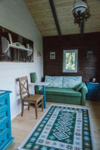 uma sala de estar com um sofá verde e uma mesa em RESETówka - chatka na odludziu do wynajęcia em Jaszczurowa