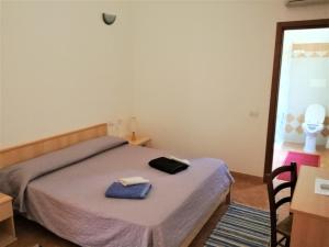 a bedroom with a bed with a blue towel on it at Il Lentischio del Sinis in Putzu Idu