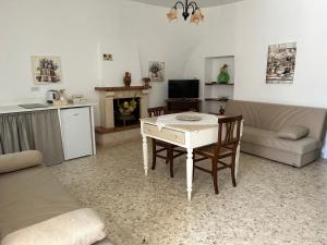 sala de estar con mesa, sofá y cocina en Agli Antichi Trulli B&B In Masseria, en Alberobello