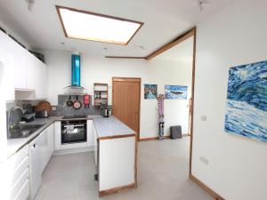 uma cozinha com armários brancos e uma clarabóia em The Gallery Lodges em Braunton