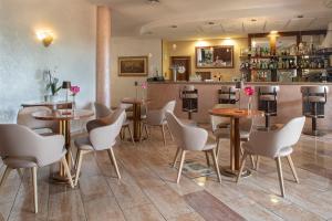 a restaurant with tables and chairs and a bar at Ancora Sport Hotel in Meolo