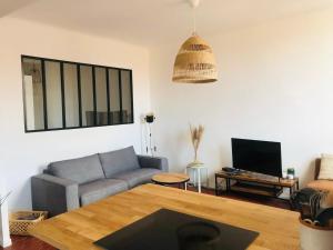 a living room with a couch and a table at Le repère des pêcheurs in Marseille +1 photo