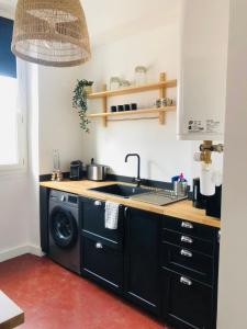 a kitchen with a sink and a washing machine at Le repère des pêcheurs in Marseille