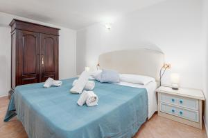 um quarto com uma cama azul com toalhas em Casa la gattina em Nuragheddu