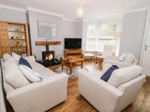 a living room with two white couches and a fireplace at 1 River View Terrace in Llandudno Junction