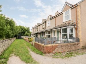 an old brick house with a fence in front of it at 1 River View Terrace in Llandudno Junction